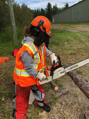 Desiree Mallett cutting tree with Chainsaw
