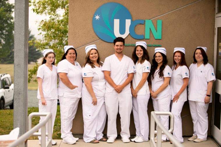 8 nursing students standing in front of a UCN building
