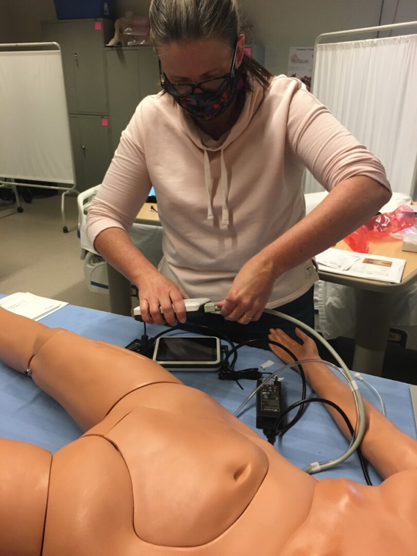 Nursing student plugging in a cable on a patient mannequin