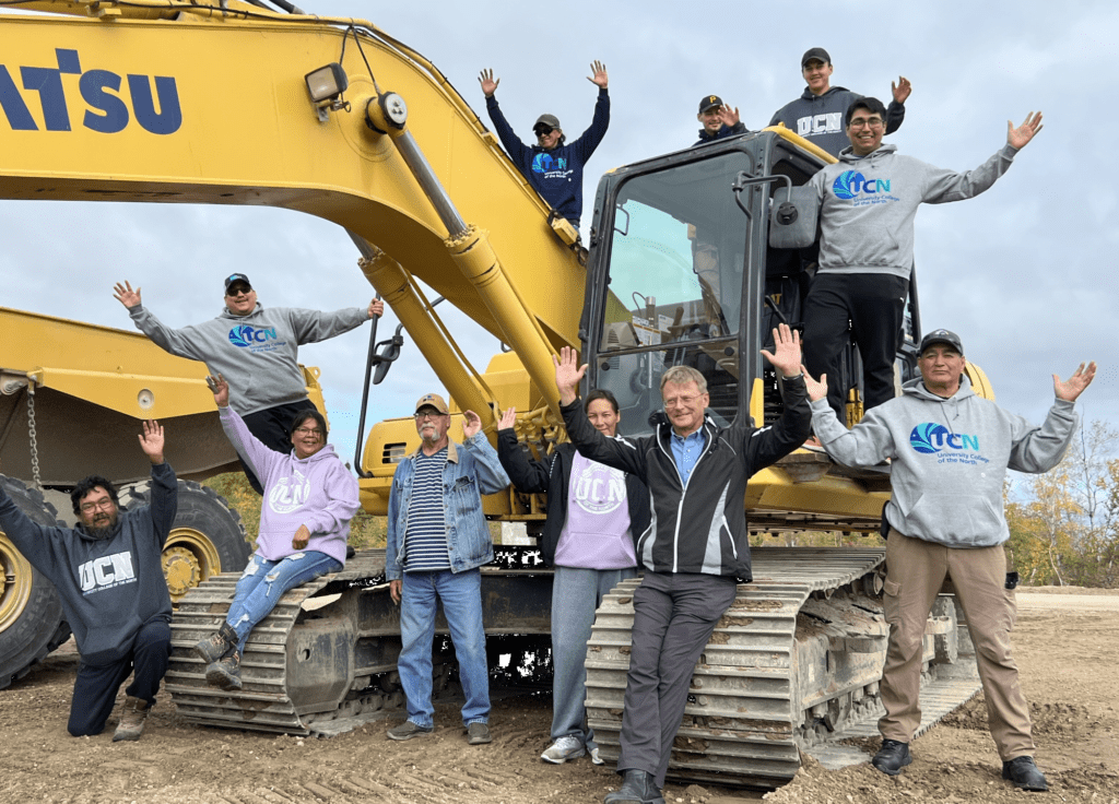 Heavy Equipment Operator grads on a large excavator.