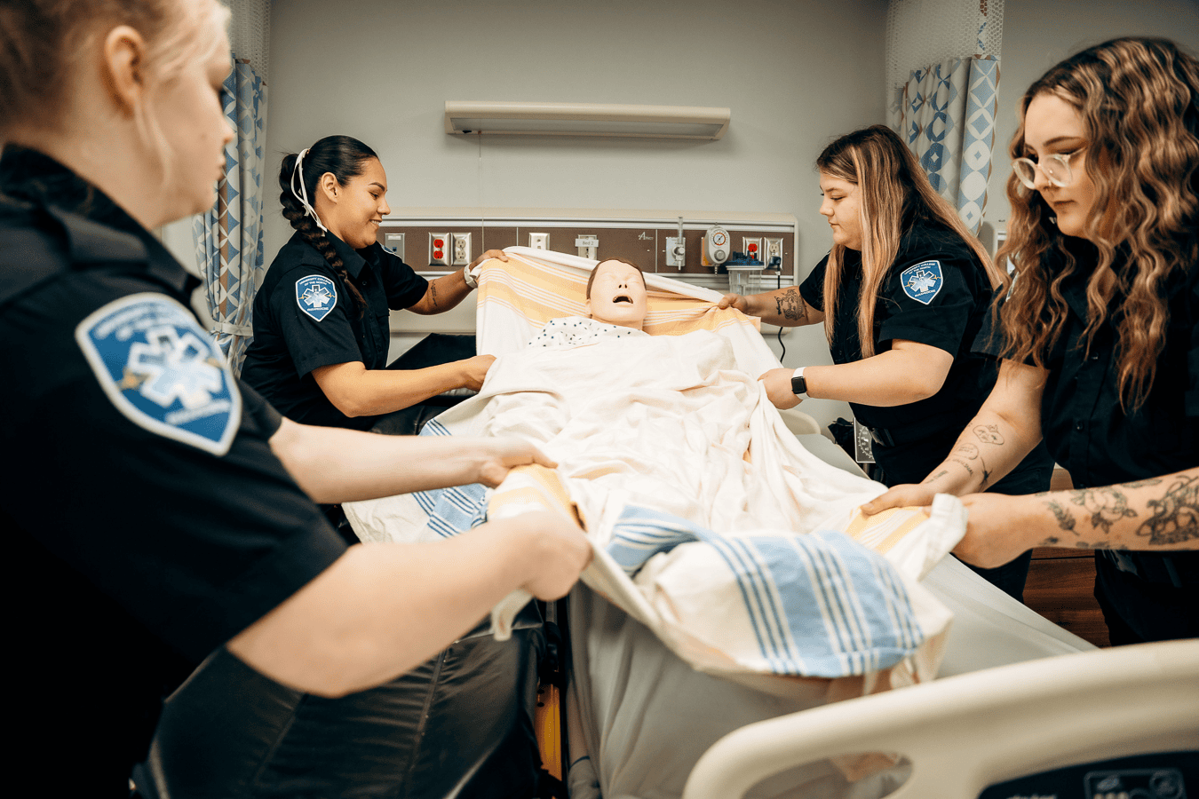 Primary care paramedic students practicing moving patient.