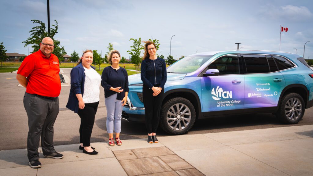 Photo: Representatives from Birchwood Auto, Johnston Group, UCN, and Payworks pose together beside a vehicle with a custom Northern Lights wrap.